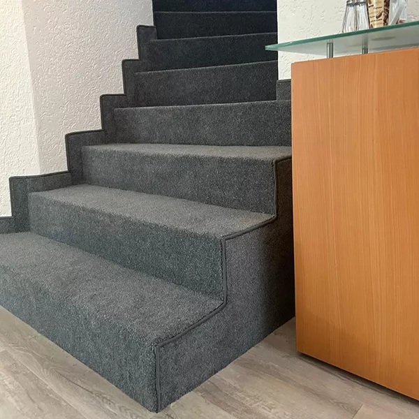 Bild zeigt eine Treppe, die mit Teppichboden verlegt wurde